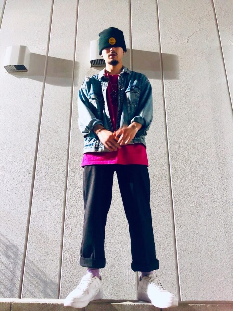 ピンクのカットソー×デニムジャケット×黒のチノパン×白スニーカー×ニット帽