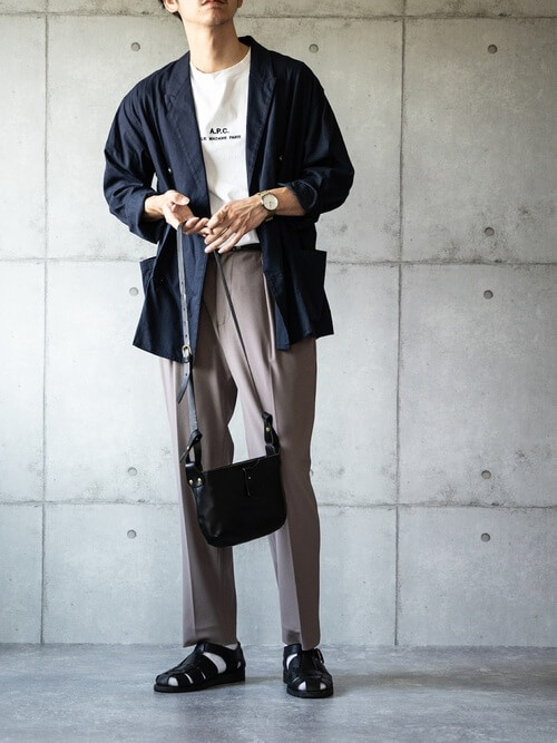 サマージャケット×白のロゴTシャツ×ベージュのスラックス×黒のグルカサンダル