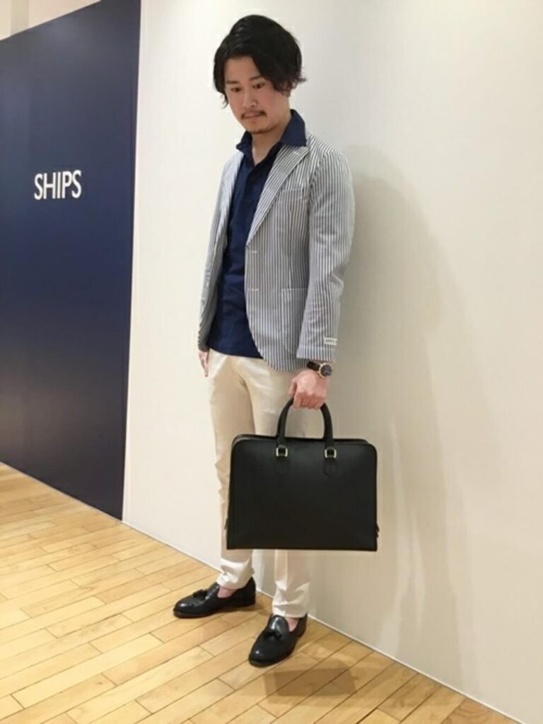 ビジネスバッグ×ストライプ柄シャツジャケット×ネイビーのポロシャツ×ベージュのドレスパンツ×ローファー