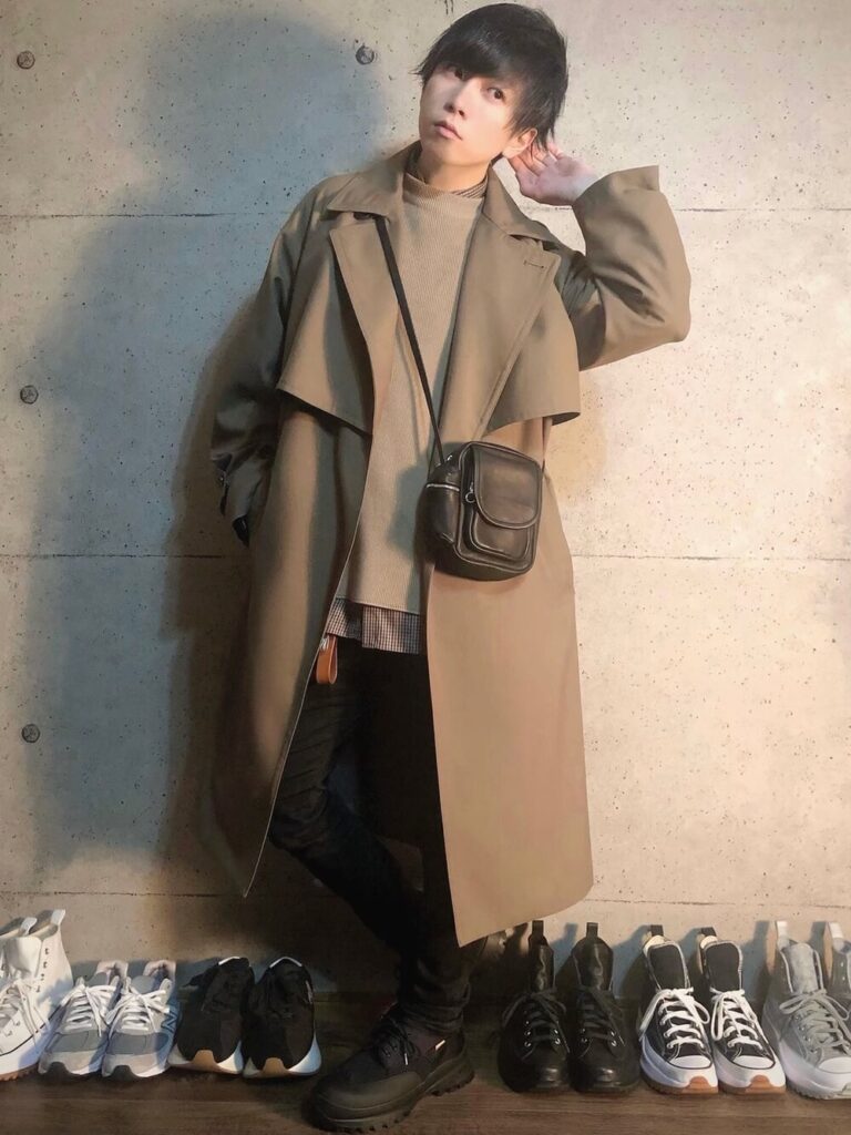 キャメルのトレンチコート×ベージュのニット×チェックシャツ×黒スキニー×黒スニーカー
