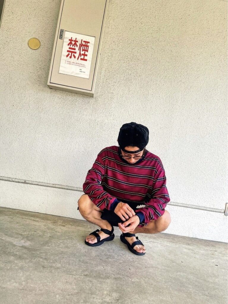赤のカットソー×黒のショートパンツ×サンダル×キャップ